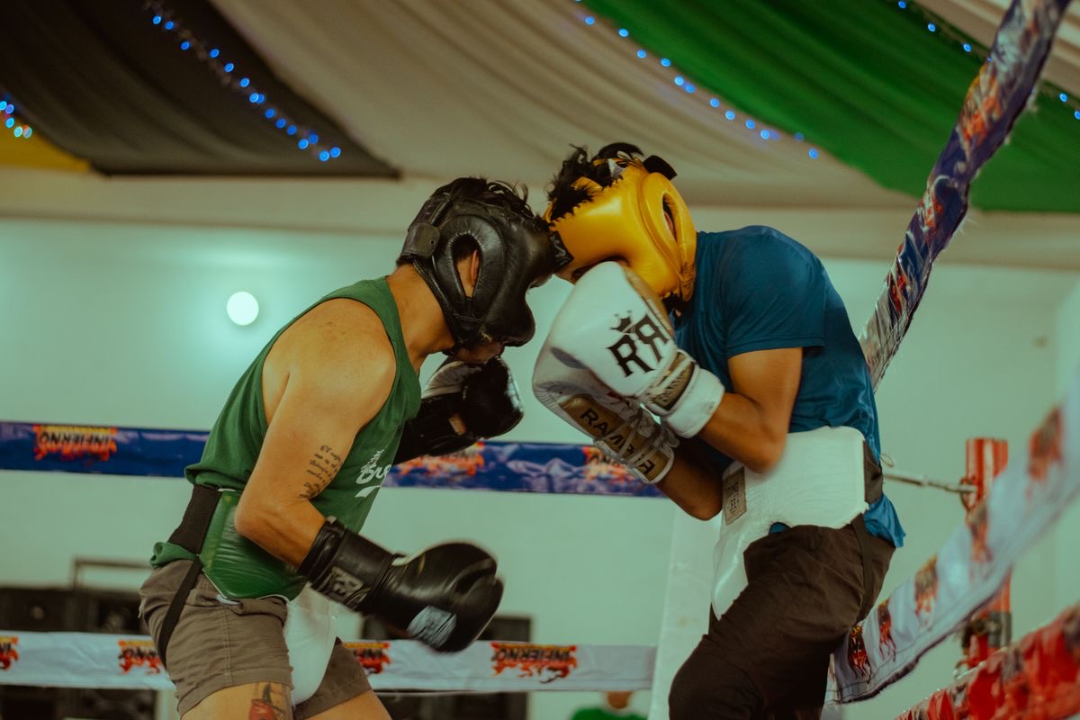 Two amateur boxers in headgear exchanging punches in a bout