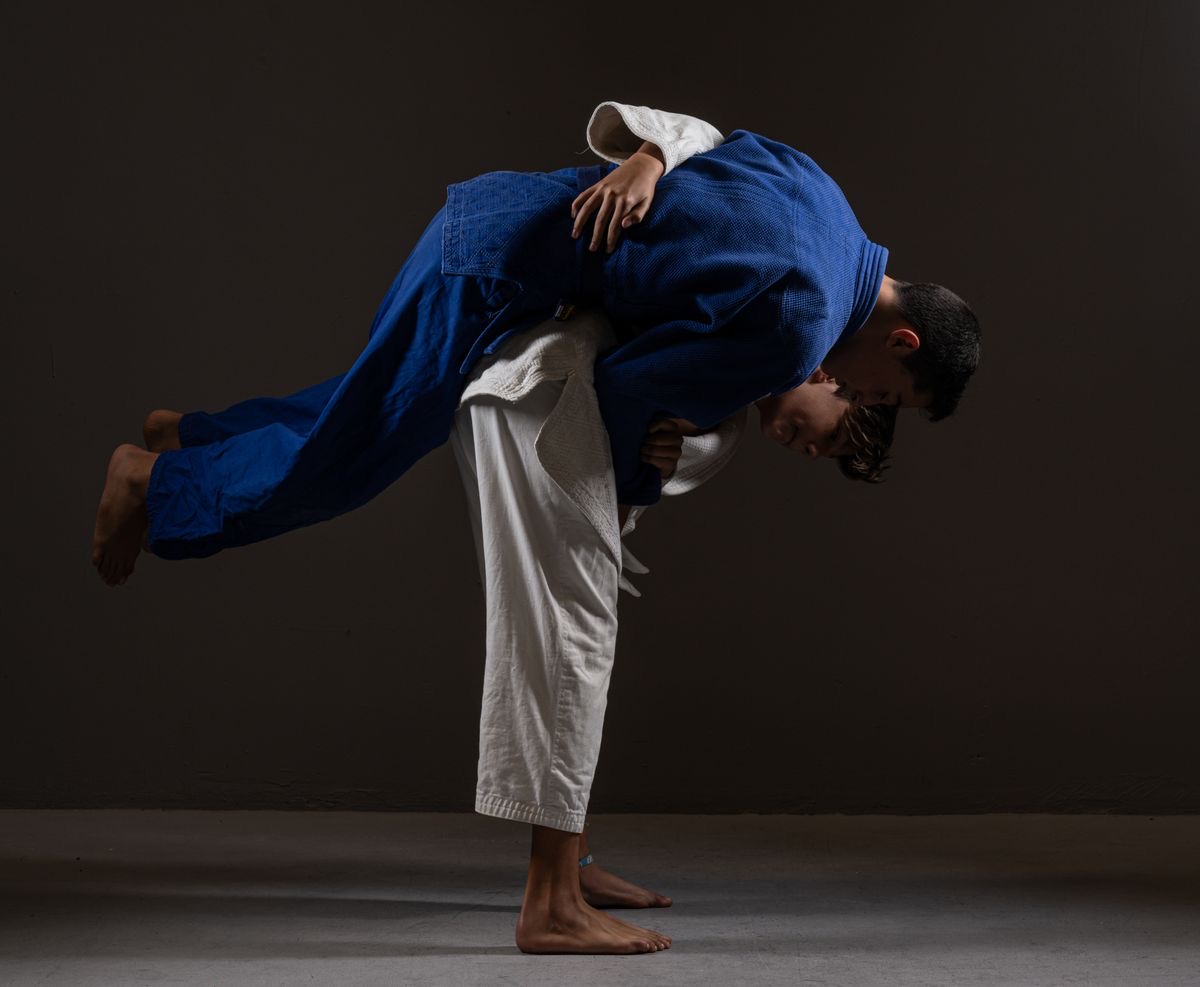 A judoka loading a partner onto his back for a shoulder throw