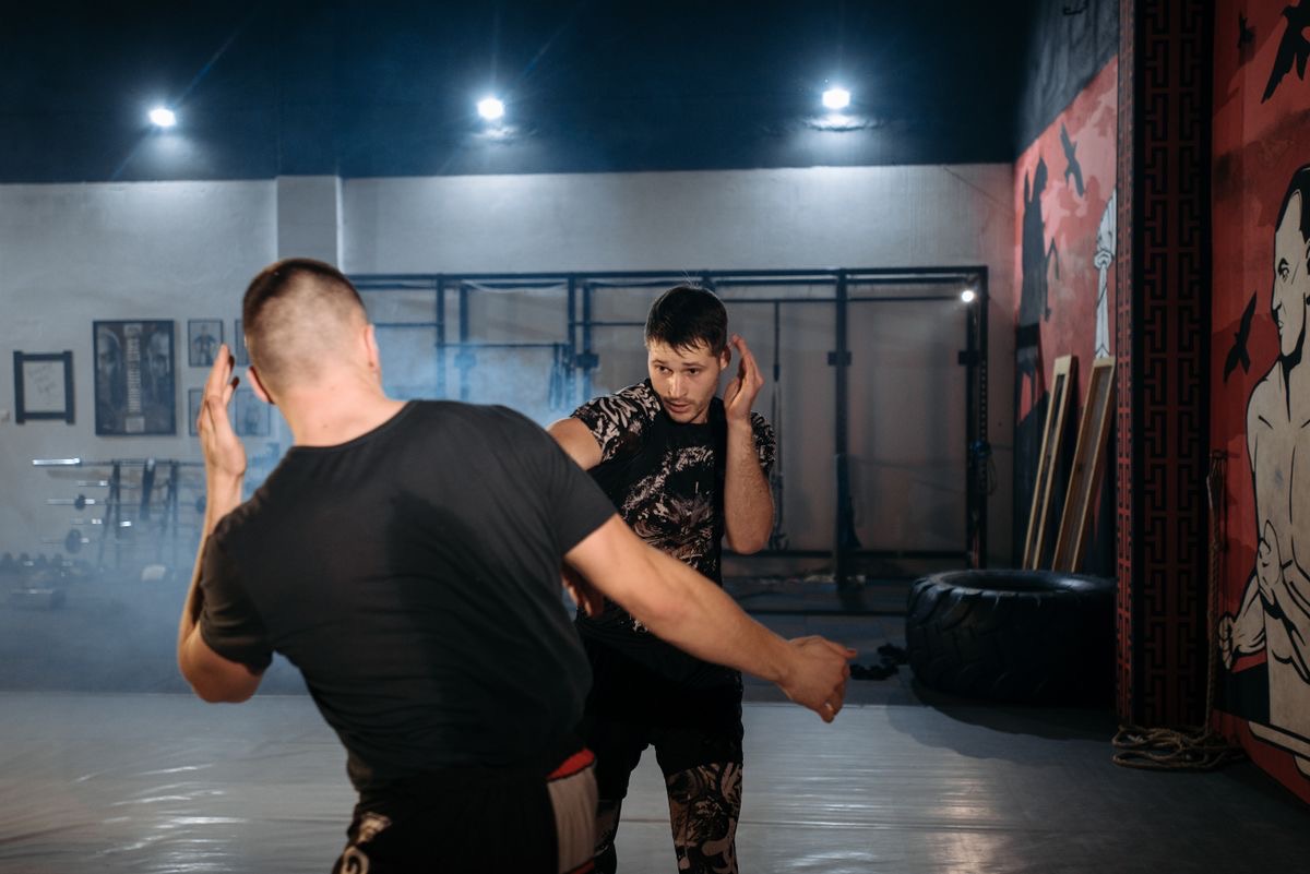 An MMA coach working a hand-fighting drill with a student