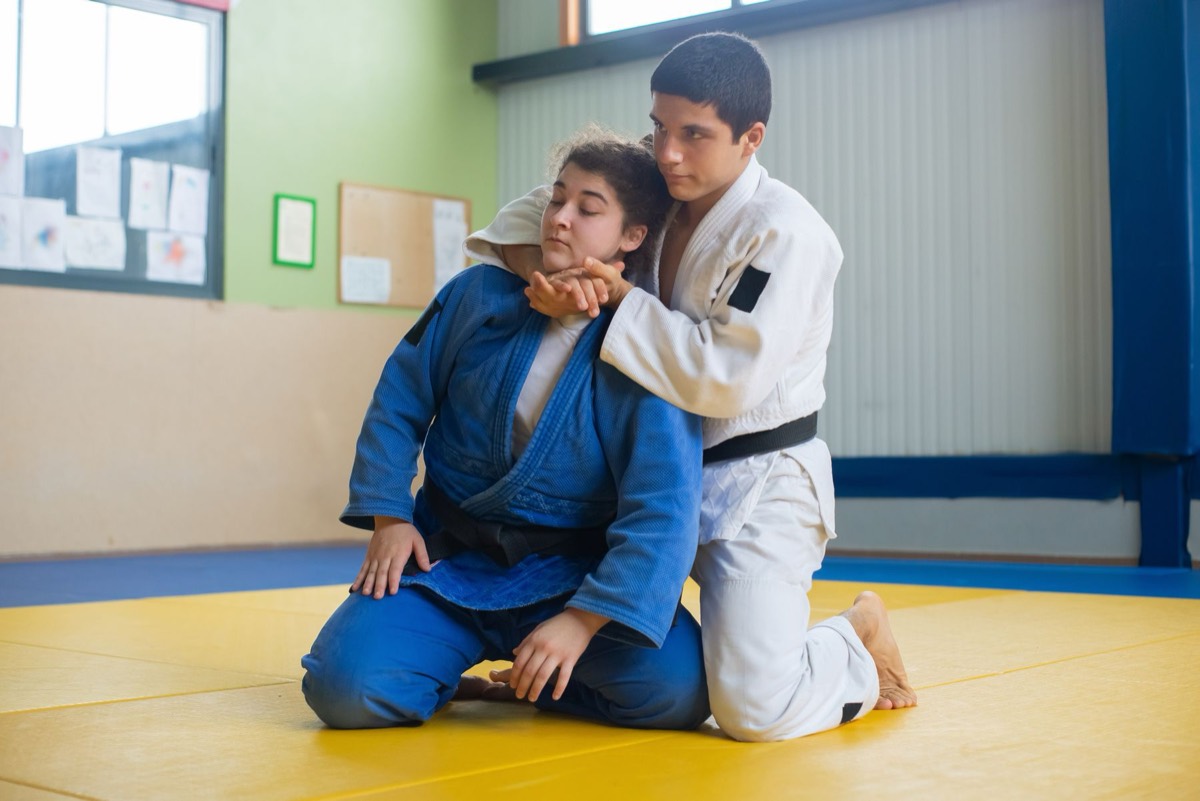 Two judo students practicing a technique together on the mat