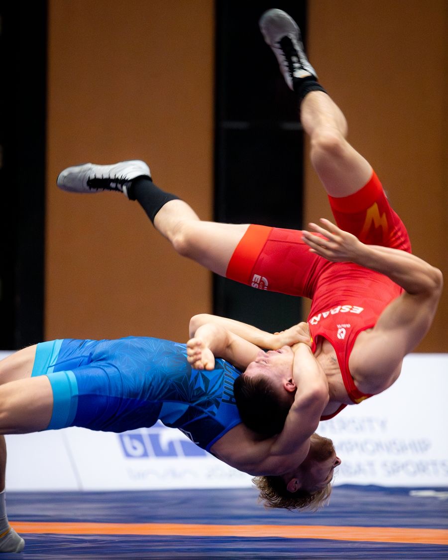 A freestyle wrestler lifting his opponent off the mat for a throw
