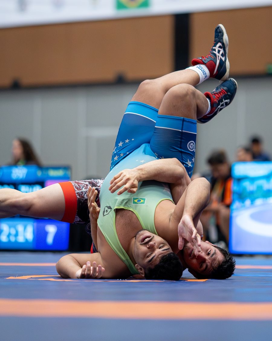 Two women wrestlers in a match, one turning the other toward a pin